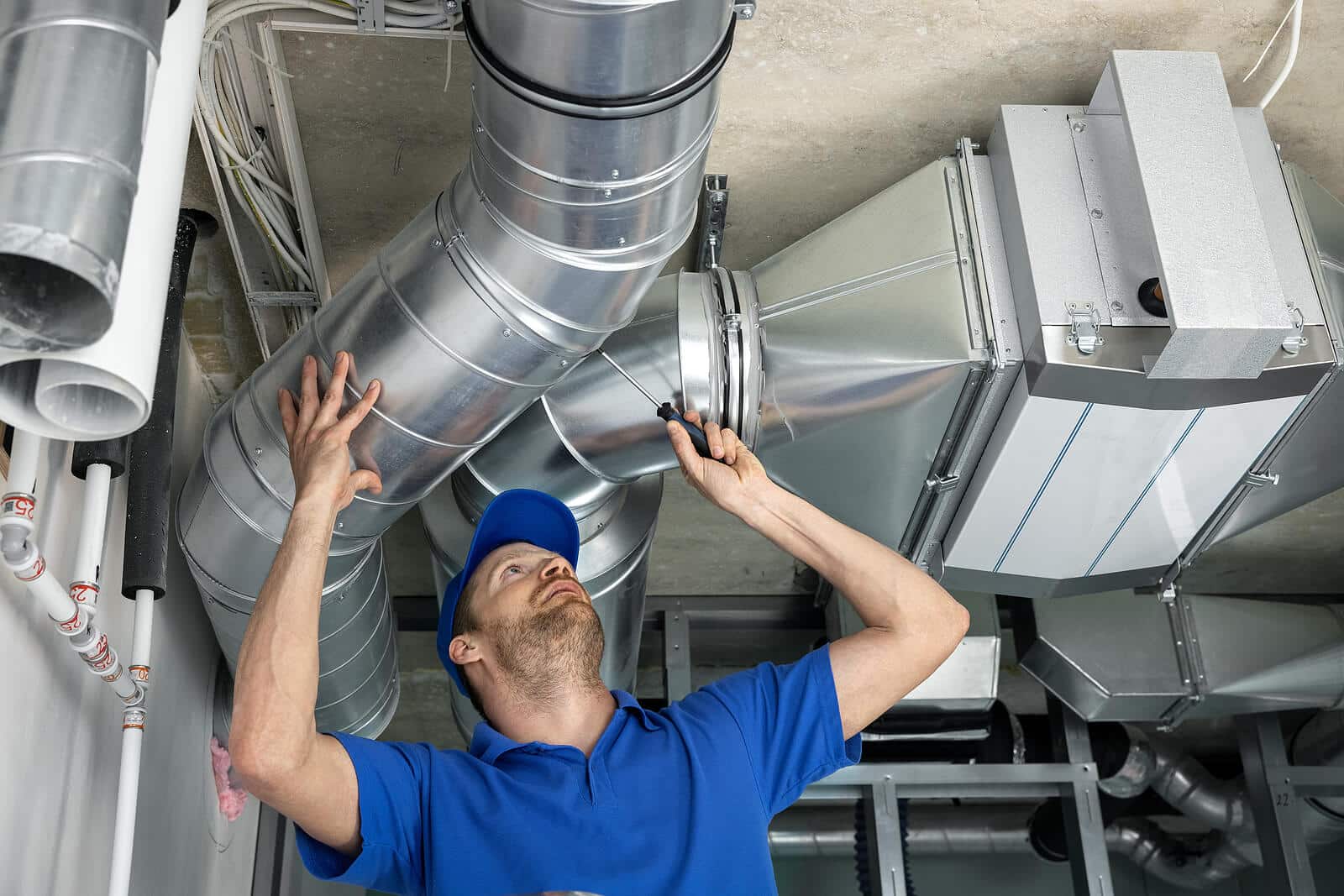 HVAC technician inspecting and repairing air ducts in Costa Mesa