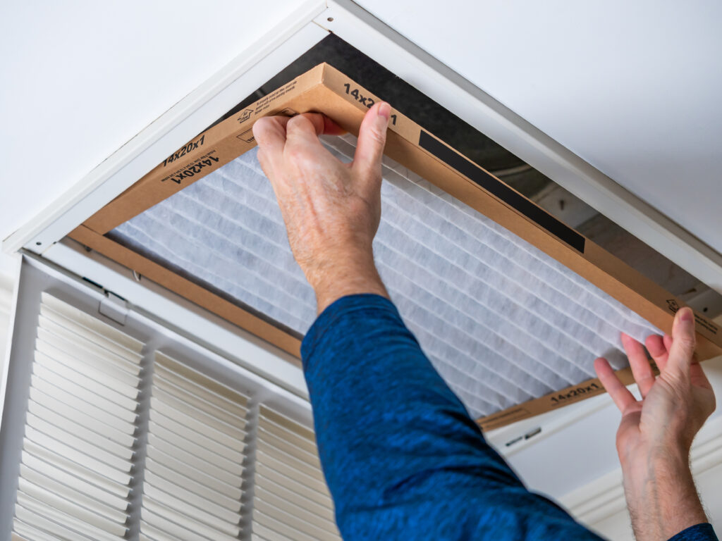 HVAC technician replacing a home air filter in Costa Mesa