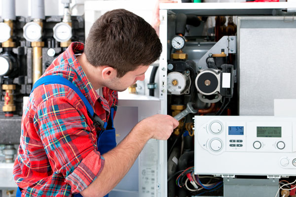 Heating technician repairing boiler controls in Costa Mesa