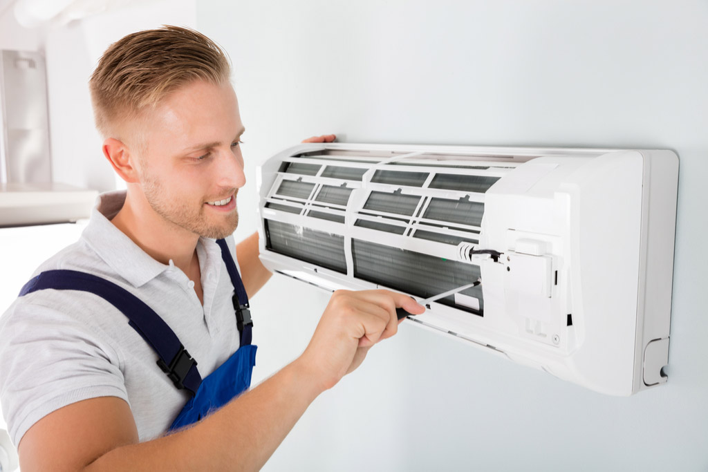 HVAC technician maintaining a ductless air conditioner in Costa Mesa